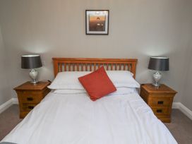 A bedroom with a bed and bedside tables at Rosefinch in Lucker