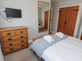 A bedroom with a bed and dresser at Rosefinch in Lucker