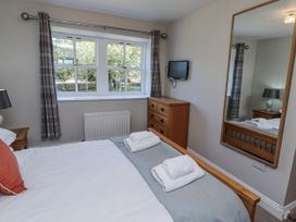 A bedroom with a bed and a television at Rosefinch in Lucker