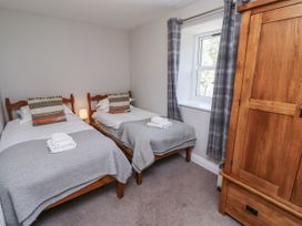 A bedroom with two beds and a wardrobe at Rosefinch in Lucker