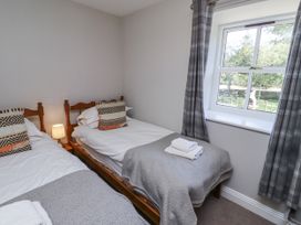 A bedroom with two beds and a window at Rosefinch in Lucker