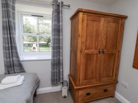 A bedroom with a wardrobe and window at Rosefinch in Lucker