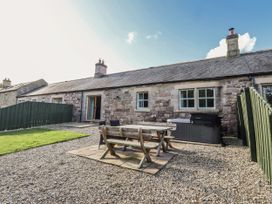 A garden with a table and chairs at Rosefinch in Lucker