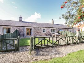 An outdoor view of a stone house with a garden area at Rosefinch in Lucker