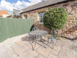 An outdoor area with a table and chairs at Rosefinch in Lucker