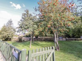 A garden with trees and a gate at Rosefinch in Lucker