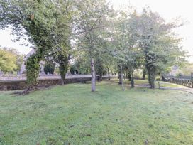 A garden with trees and a pathway at Rosefinch in Lucker