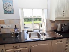 A kitchen with a sink and wine glasses at Chaffinch in Lucker