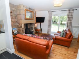 A living room with a fireplace and sofa at Chaffinch in Lucker