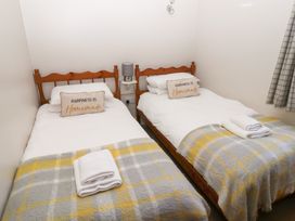 A bedroom with two beds and a bedside table at Chaffinch in Lucker
