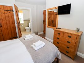 A bedroom with a bed and television at Chaffinch Lucker