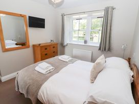 A bedroom with a bed and dresser at Chaffinch in Lucker