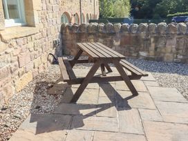 A picnic table on a patio in the garden at Chaffinch in Lucker