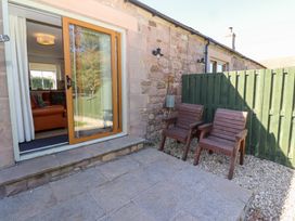 An outdoor area with chairs and a view into the living room at Chaffinch in Lucker