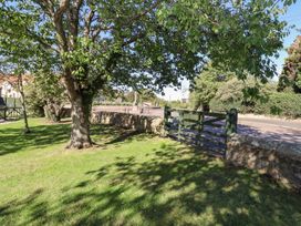 A garden with a tree and a gate at Chaffinch in Lucker
