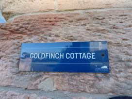 A sign with the name Goldfinch Cottage at Goldfinch in Lucker
