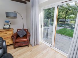 A living room with an armchair and sliding doors at Goldfinch in Lucker