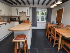 A kitchen with a dining table and stools at Goldfinch in Lucker