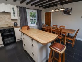 A kitchen with a dining area and wooden island at Goldfinch in Lucker