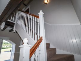 A staircase with a handrail and light fixture at Goldfinch in Lucker
