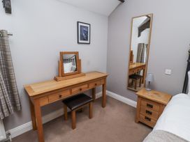 A bedroom with a dressing table and mirror at Goldfinch in Lucker