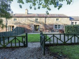 A stone house with a garden and a fence at Goldfinch in Lucker