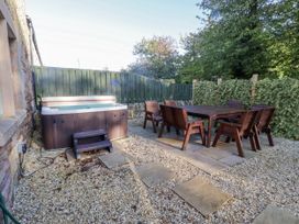 An outdoor area with a hot tub and dining set at Goldfinch in Lucker