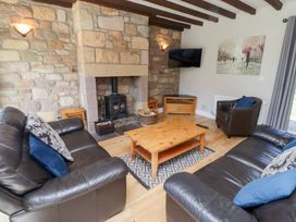 A living room with a fireplace and sofa at Bullfinch in Lucker