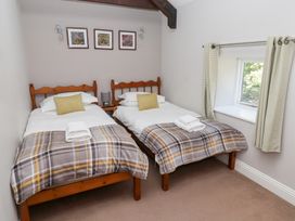 A bedroom with two single beds and wall art at Bullfinch in Lucker