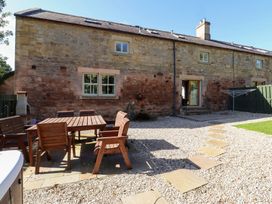 A garden with a wooden table and chairs at Bullfinch in Lucker