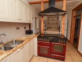 A kitchen with an oven and sink at Adderstone Cottage in Bamburgh