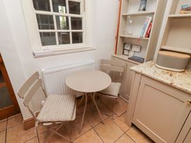 A kitchen with a table and chairs at Adderstone Cottage in Bamburgh
