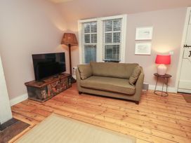A living room with a sofa and television at Armstrong Cottages No6 Bamburgh