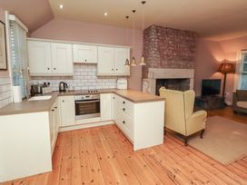 A kitchen with cabinets, sink, and stove at Armstrong Cottages No6 in Bamburgh
