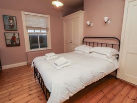 A bedroom with a bed and artworks on the wall at Armstrong Cottages No6 Bamburgh