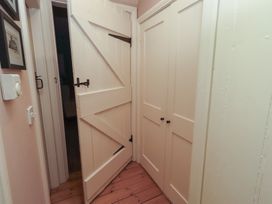 A hallway with a door and closet at Armstrong Cottages No6 Bamburgh