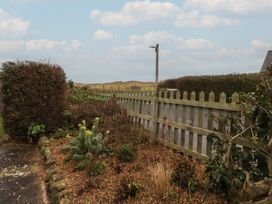 A garden area with a fence and plants at Armstrong Cottages No6 Bamburgh