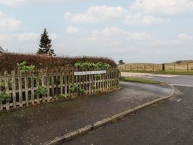A sign indicating Armstrong Cottages at a road junction in Bamburgh