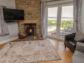 A living room with a fireplace and television at Pipistrelle in Bamburgh