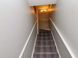A staircase with carpet and light fixture at Pipistrelle in Bamburgh