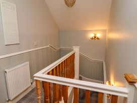 A staircase and hallway with a radiator and wall art at Pipistrelle in Bamburgh