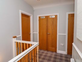 A hallway with wooden doors and handrail at Pipistrelle in Bamburgh