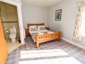 A bedroom with a bed and attached bathroom at Pipistrelle in Bamburgh