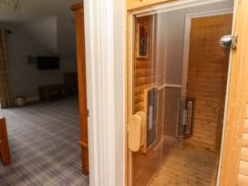 A sauna with a wooden door in a room with a television at Pipistrelle in Bamburgh