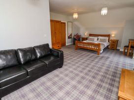 A bedroom with a bed, sofa, and wardrobe at Pipistrelle in Bamburgh