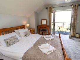A bedroom with a bed and a balcony at Pipistrelle in Bamburgh