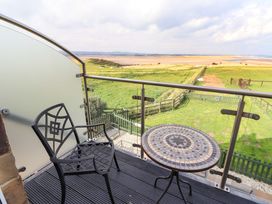 A balcony with a table and chair at Pipistrelle in Bamburgh