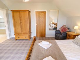 A bedroom with a wardrobe, bed, and mirror at Pipistrelle in Bamburgh