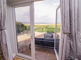 A living room with a view of outdoor furniture and a fence at Pipistrelle in Bamburgh