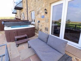 An outdoor space with a hot tub and sofa at Pipistrelle in Bamburgh